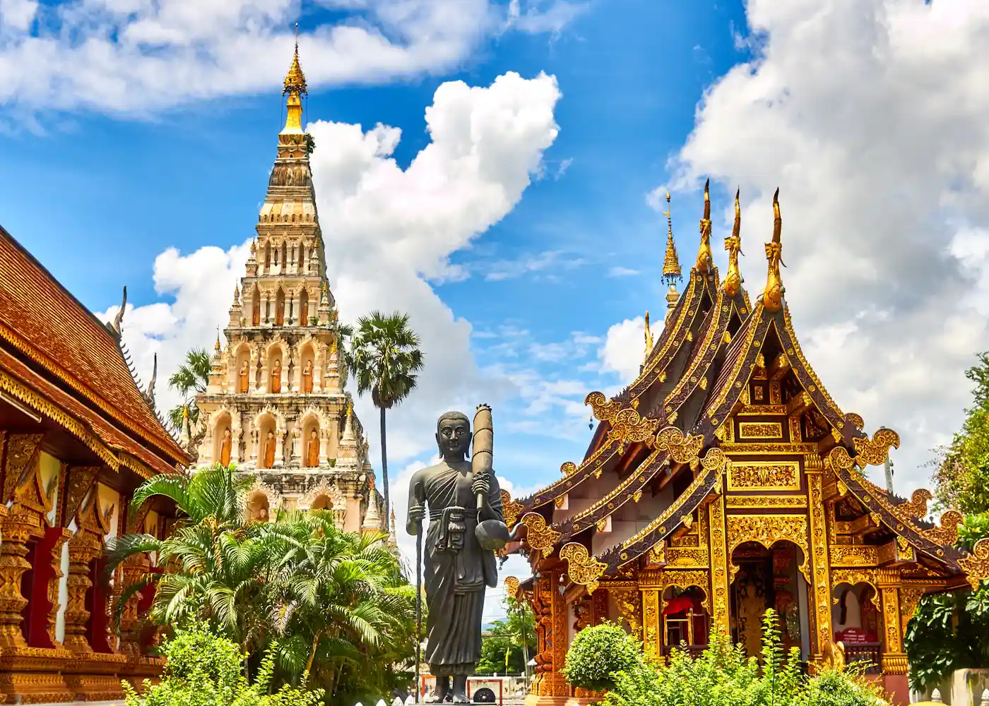 Ornate golden temple roofs beneath a blue sky in Thailand